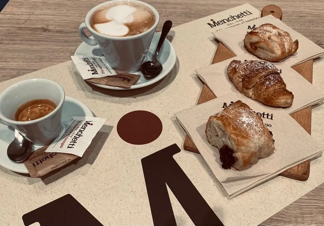 Cappuccino con latte art, caffè espresso e cornetti su tovaglioli Menchetti
