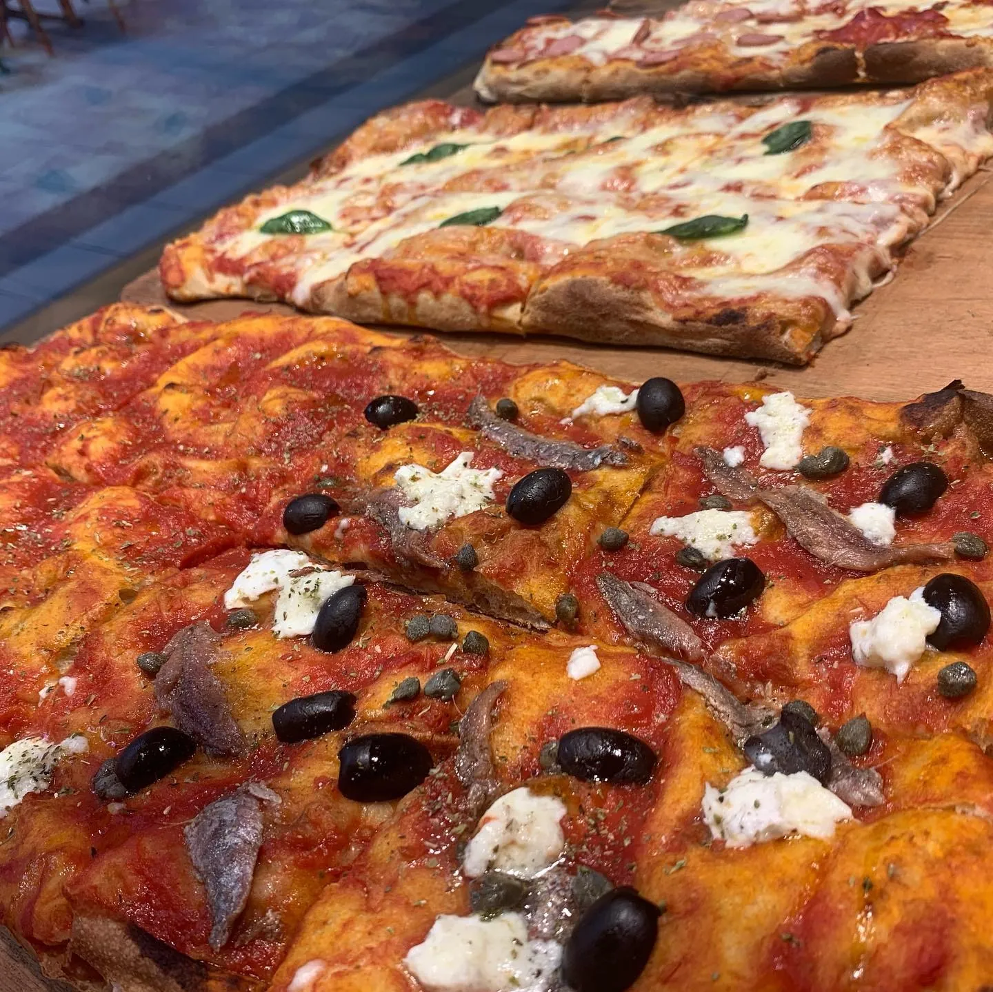 Teglie di pizza margherita e marinara appena sfornate