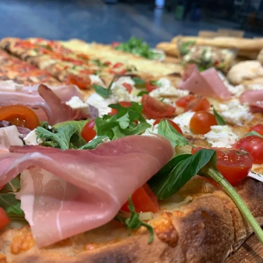 Pizza al taglio a lunga lievitazione con prosciutto crudo, pomodorini e basilico
