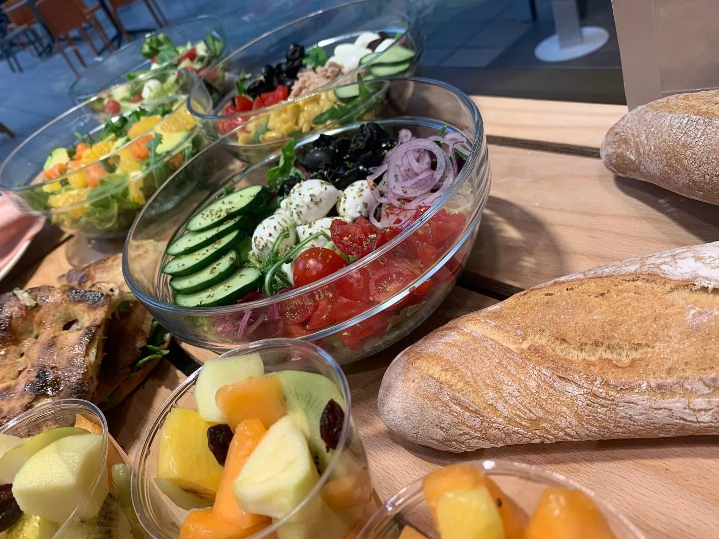 Tavolo con insalatone, pane fresco e frutta del pranzo